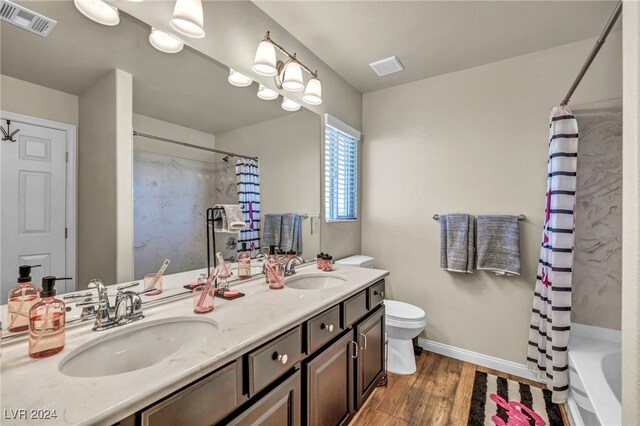 full bathroom featuring toilet, shower / tub combo, wood-type flooring, and vanity