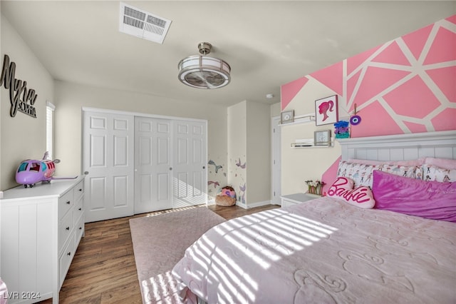 bedroom with dark wood-type flooring and a closet