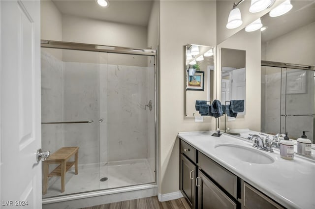 bathroom featuring an enclosed shower, vanity, and hardwood / wood-style floors