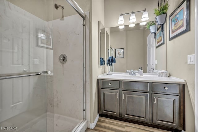 bathroom featuring a shower with shower door, wood-type flooring, and vanity