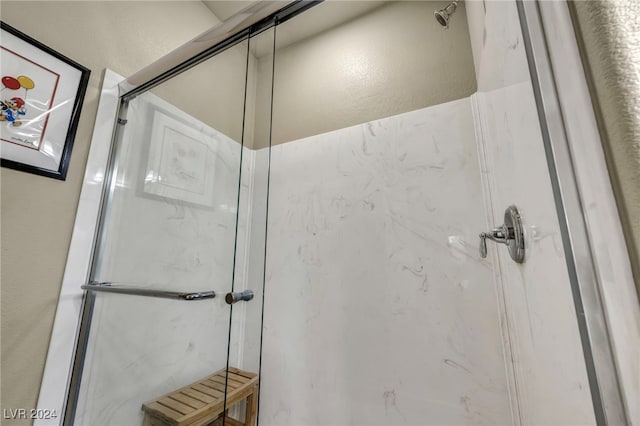 bathroom featuring a shower with door