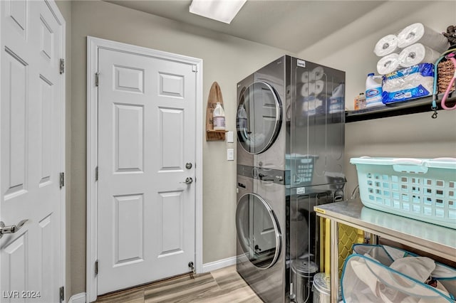 laundry room with light hardwood / wood-style flooring and stacked washer and dryer