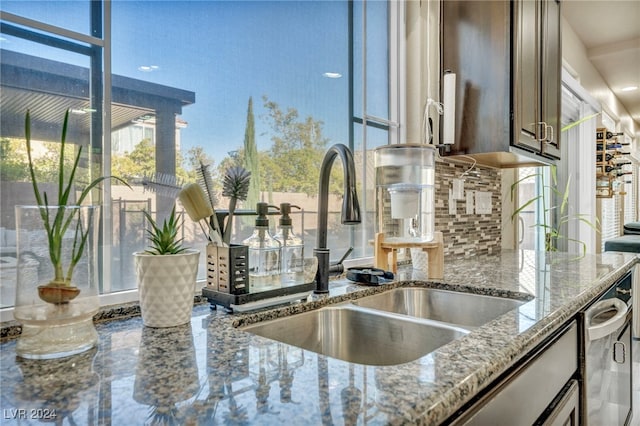 kitchen with light stone counters, backsplash, and sink