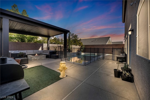 patio terrace at dusk featuring an outdoor living space with a fire pit and a fenced in pool