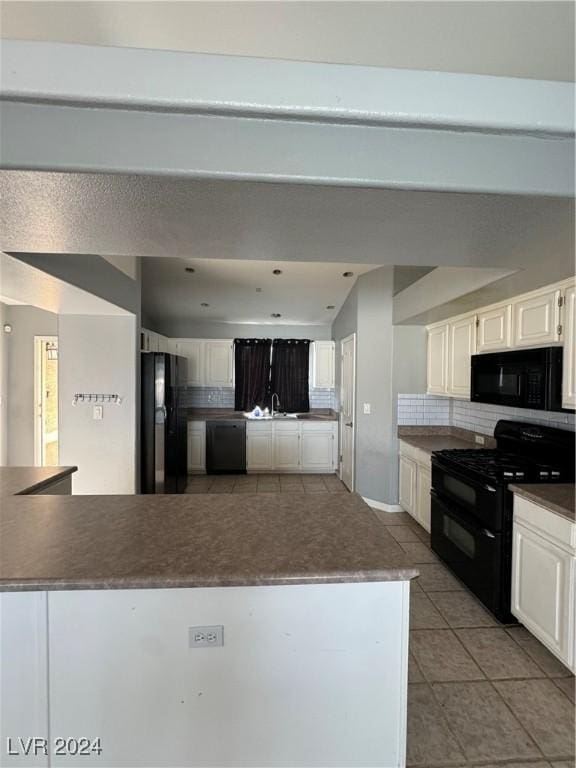 kitchen featuring tasteful backsplash, sink, black appliances, light tile patterned floors, and white cabinets