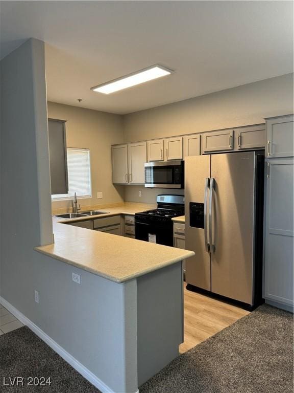 kitchen featuring kitchen peninsula, sink, gray cabinetry, and stainless steel appliances