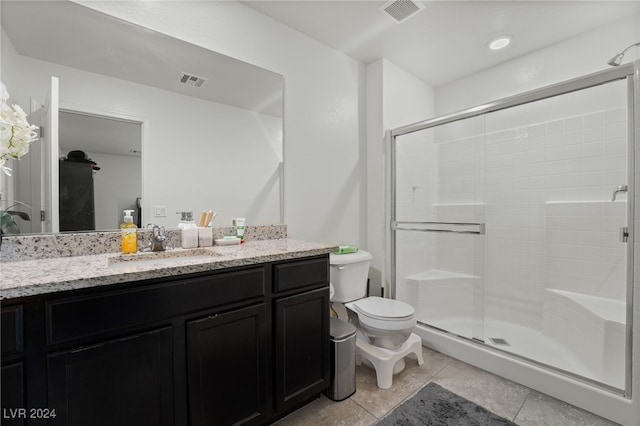 bathroom with vanity, toilet, an enclosed shower, and tile patterned flooring