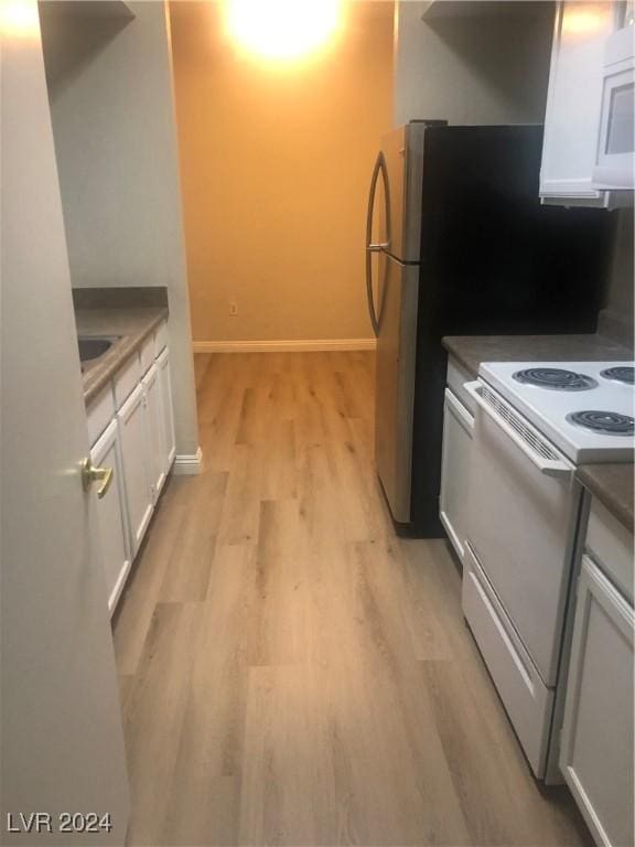 kitchen featuring white appliances, white cabinetry, and light hardwood / wood-style flooring