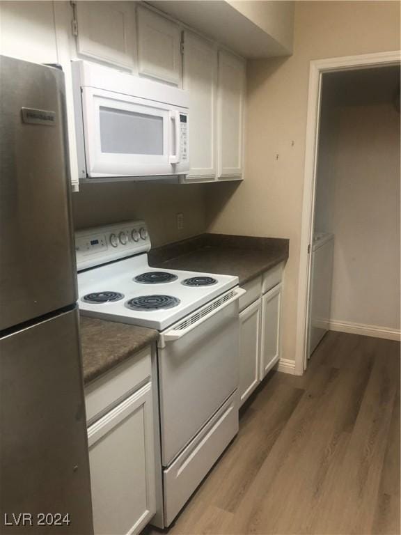 kitchen featuring white cabinetry, dark hardwood / wood-style flooring, and white appliances