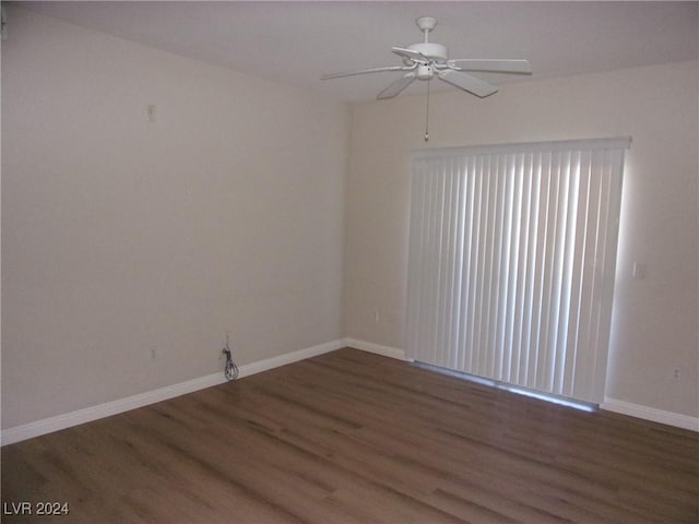 empty room with dark hardwood / wood-style flooring and ceiling fan