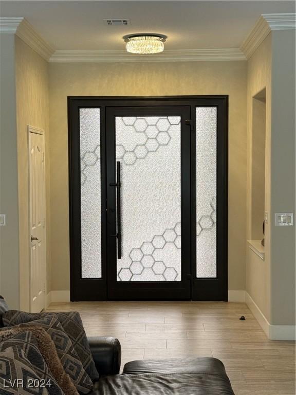 entryway featuring crown molding and light wood-type flooring