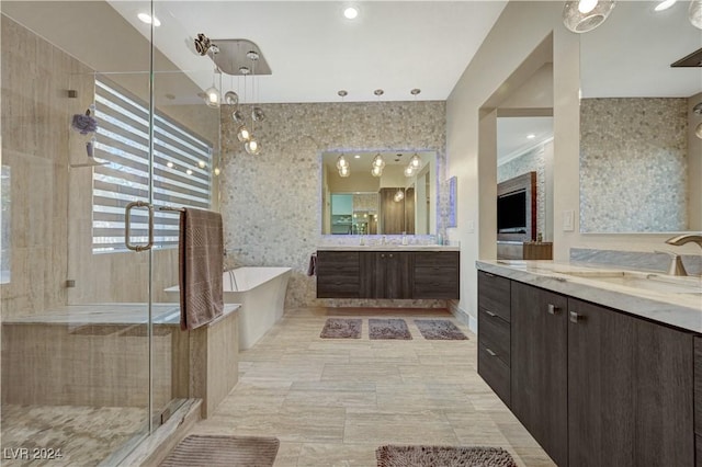 bathroom with vanity and shower with separate bathtub