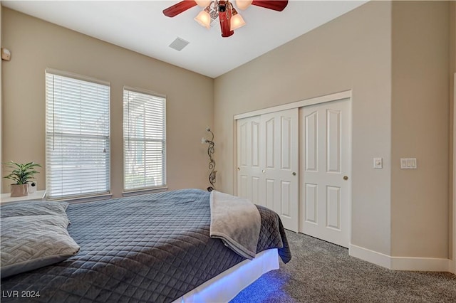 carpeted bedroom with ceiling fan and a closet