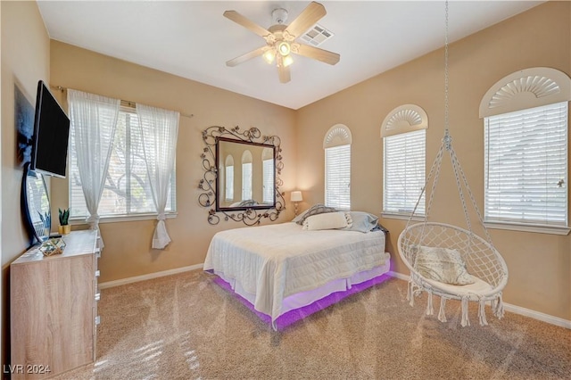 carpeted bedroom with ceiling fan and multiple windows