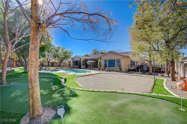 rear view of property with a fenced in pool