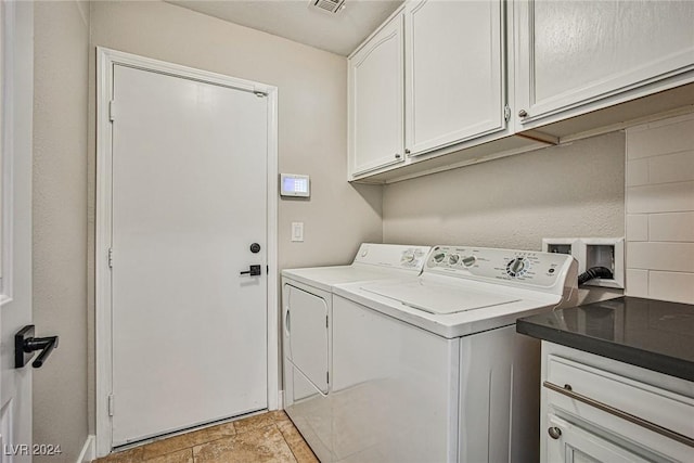 laundry room featuring separate washer and dryer and cabinets