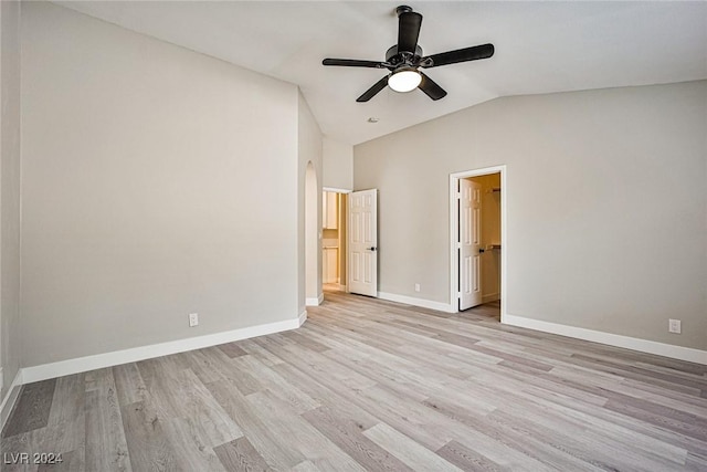 unfurnished bedroom with ensuite bathroom, ceiling fan, vaulted ceiling, and light wood-type flooring