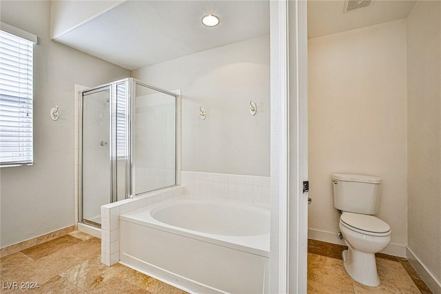 bathroom featuring separate shower and tub, toilet, and plenty of natural light