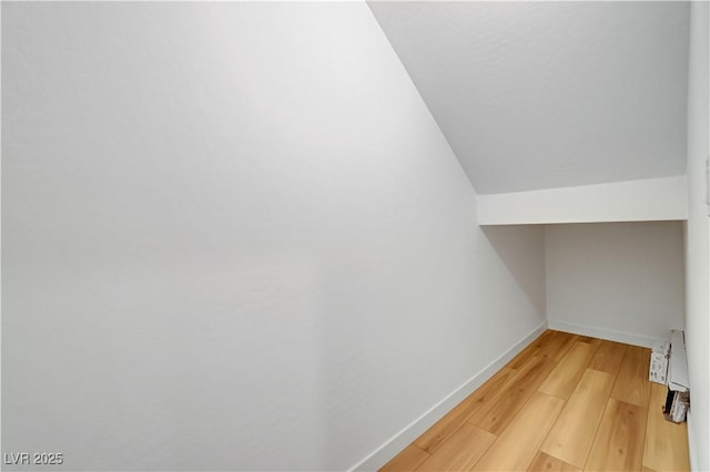 spacious closet featuring lofted ceiling and hardwood / wood-style flooring