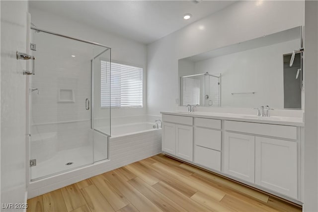 bathroom featuring independent shower and bath, hardwood / wood-style floors, and vanity