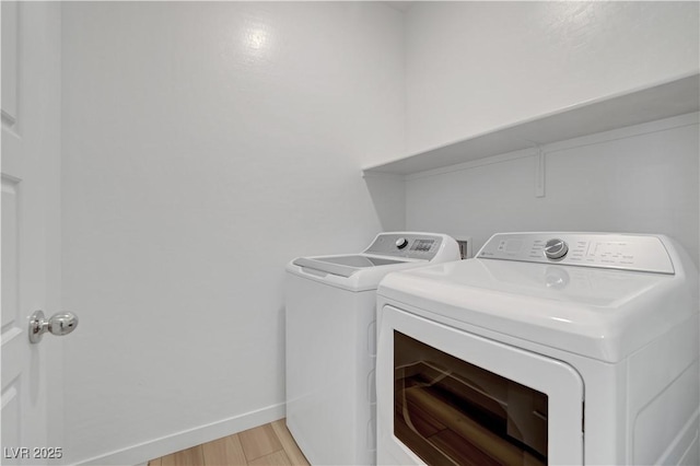 clothes washing area featuring light hardwood / wood-style flooring and washer and clothes dryer