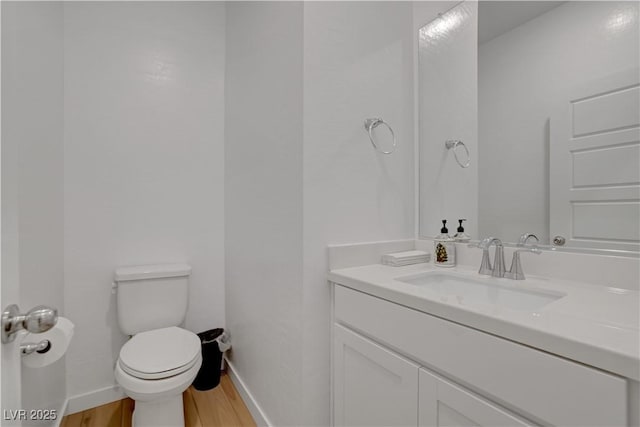 bathroom featuring toilet, hardwood / wood-style flooring, and vanity