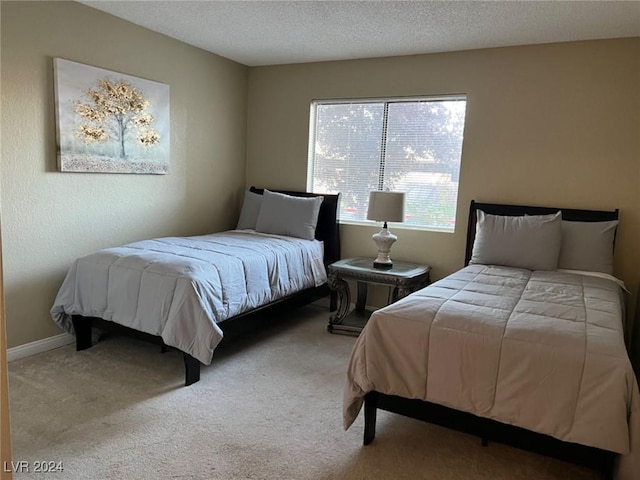 bedroom featuring a textured ceiling and light colored carpet