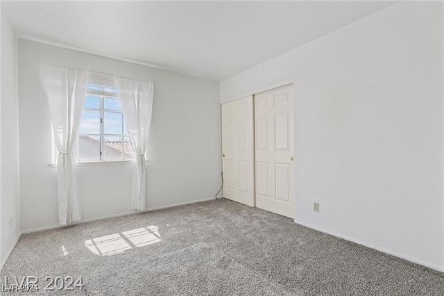 unfurnished bedroom featuring carpet flooring and a closet