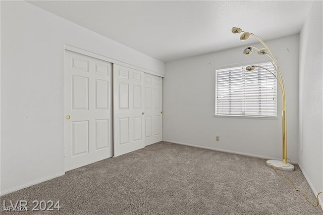 unfurnished bedroom featuring carpet floors and a closet