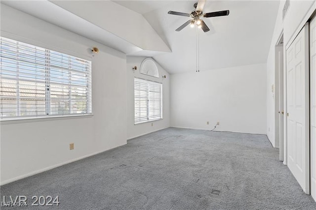 unfurnished bedroom with ceiling fan, a closet, carpet floors, and vaulted ceiling