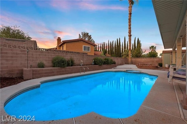 pool at dusk with a patio