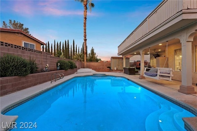 pool at dusk with a patio area