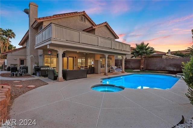 pool at dusk featuring a patio area, an in ground hot tub, outdoor lounge area, and a grill