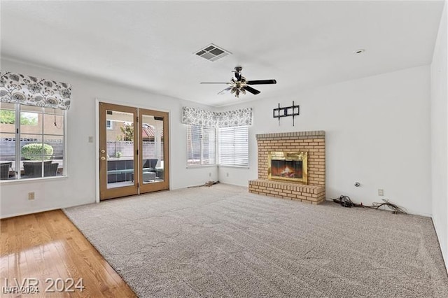 unfurnished living room with a fireplace, ceiling fan, and hardwood / wood-style floors