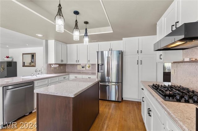 kitchen with a center island, white cabinets, and stainless steel appliances