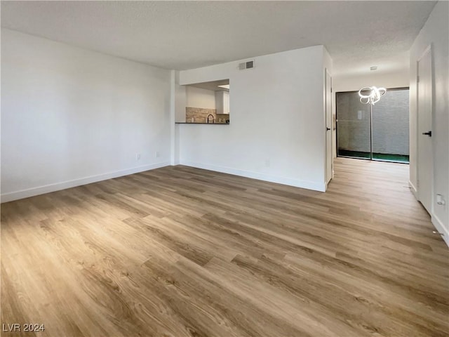 unfurnished room featuring hardwood / wood-style flooring and a textured ceiling