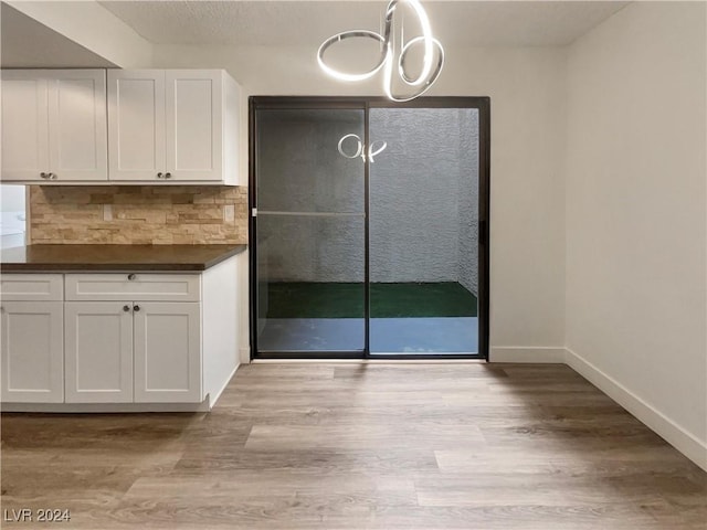 interior space with a chandelier and light hardwood / wood-style floors