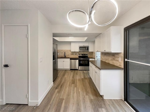 kitchen featuring white cabinets, light wood-type flooring, sink, and appliances with stainless steel finishes