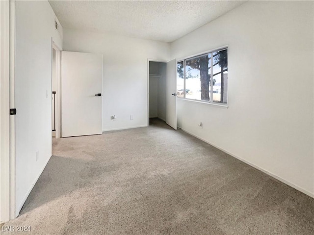 unfurnished bedroom featuring light colored carpet and a textured ceiling