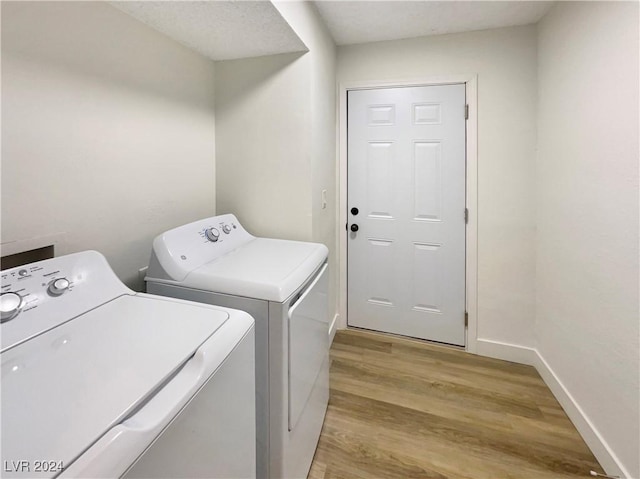 laundry area with light wood-type flooring and separate washer and dryer