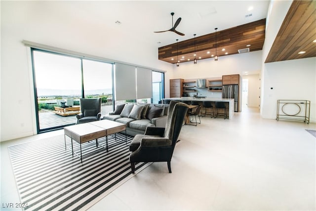 living room featuring ceiling fan and a high ceiling