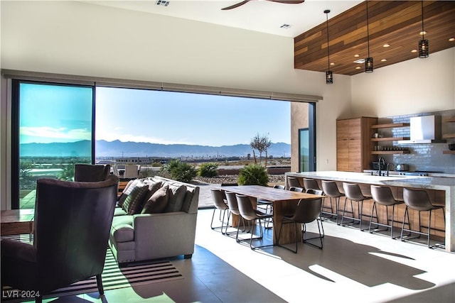 living room featuring a mountain view, ceiling fan, plenty of natural light, and a towering ceiling