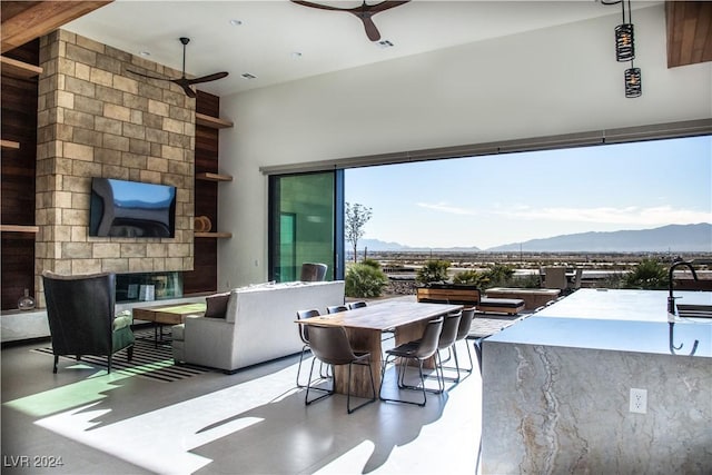 view of patio with a bar, ceiling fan, a mountain view, and an outdoor kitchen