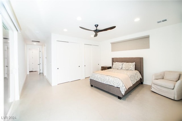 bedroom with ceiling fan and two closets