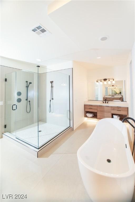 bathroom featuring tile patterned floors, vanity, and shower with separate bathtub