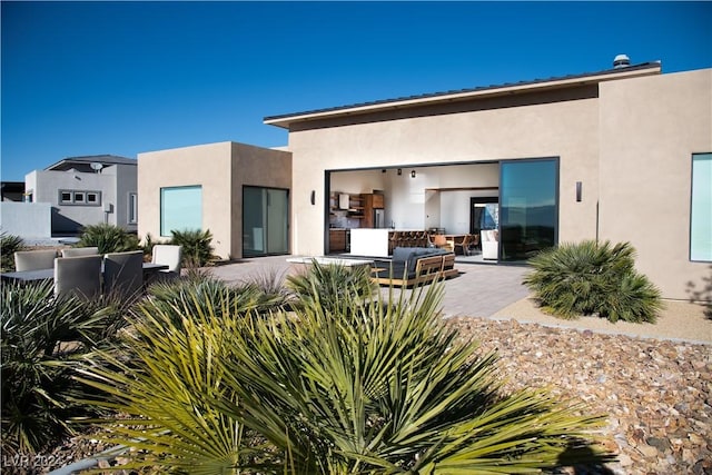 rear view of house featuring an outdoor living space and a patio