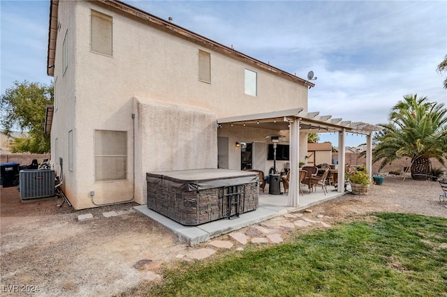 rear view of house featuring central air condition unit, a patio, and a hot tub