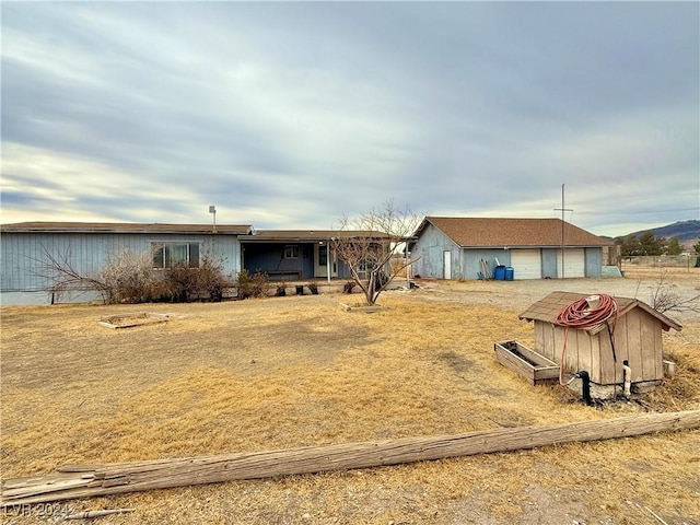 ranch-style home with a garage and an outbuilding