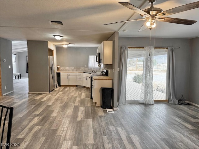 kitchen featuring backsplash, light hardwood / wood-style flooring, ceiling fan, appliances with stainless steel finishes, and white cabinetry