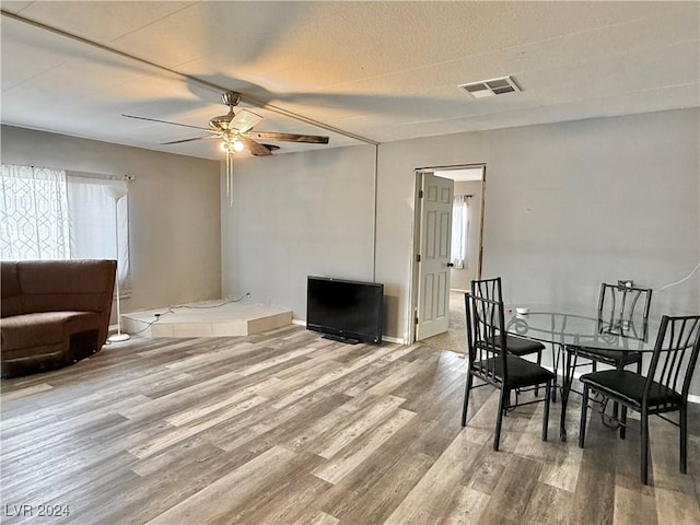 dining area featuring hardwood / wood-style floors, a textured ceiling, and ceiling fan